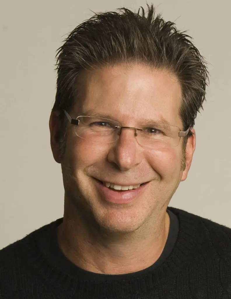 A man with glasses smiling for the camera.
