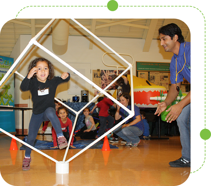 A man and child playing with an object in the shape of a cube.