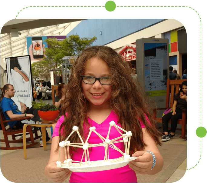 A girl holding up a paper crown.