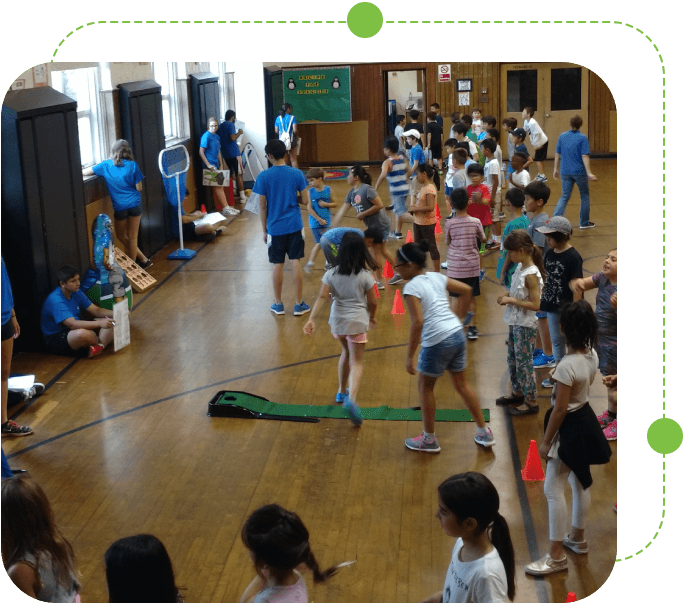 A group of children in the gym playing frisbee.