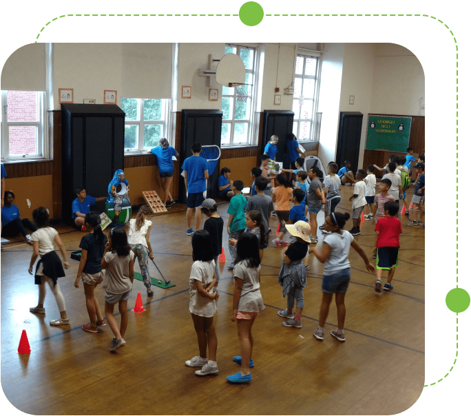 A group of children in the middle of an indoor gymnasium.