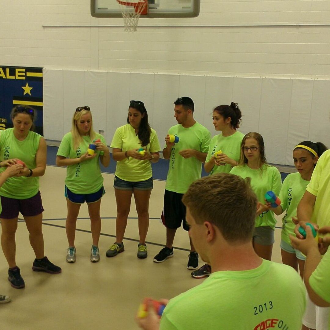 A group of people in green shirts playing wii.